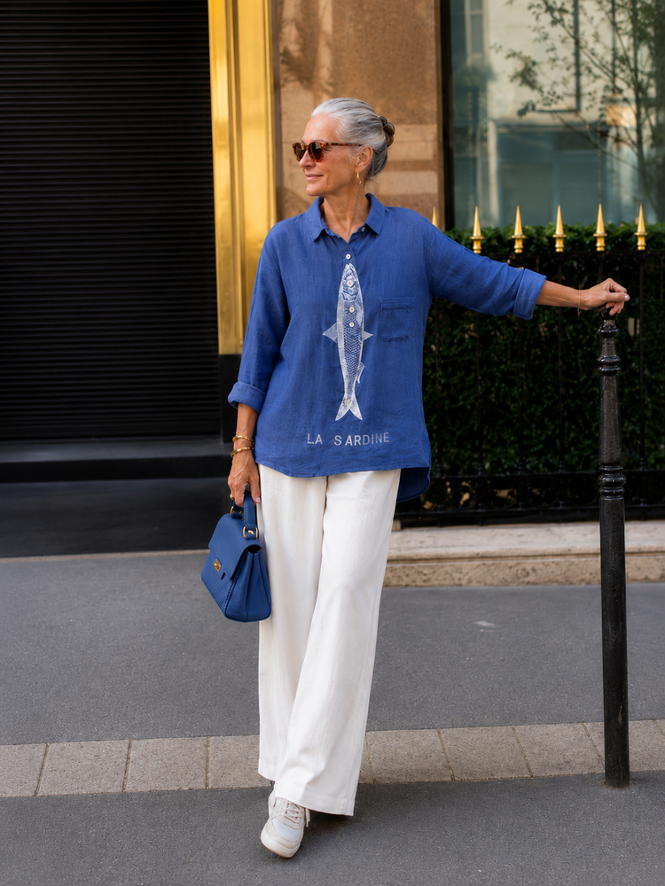 Donna con camicia blu e pantaloni bianchi